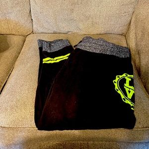 Two pair of lime green and black sweat pants.